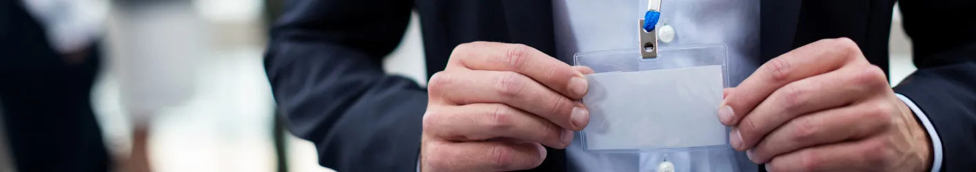 A person holding a white id tag