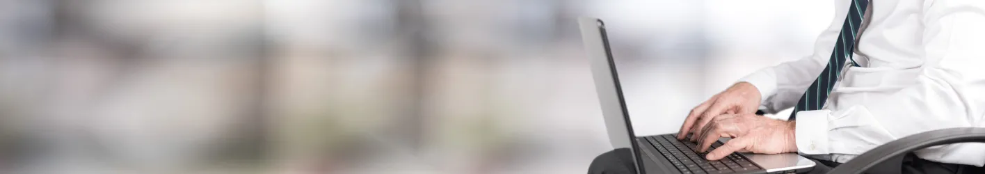 Man typing on laptop with background blurred