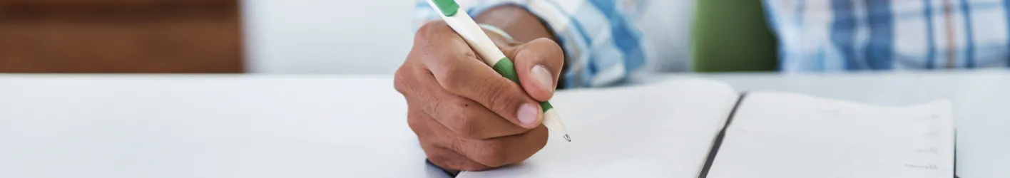 Man with pen writing in notebook 