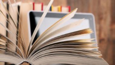 open book with computer and more books in background